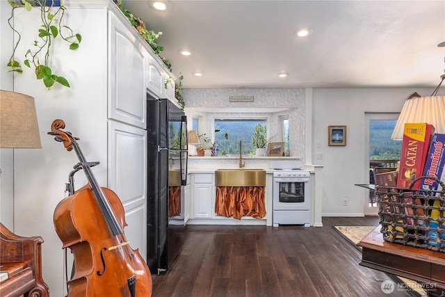239 Alpine Dr, Packwood, WA 98361 - kitchen with white range, a sink, freestanding refrigerator, white cabinetry, and dark wood-style flooring