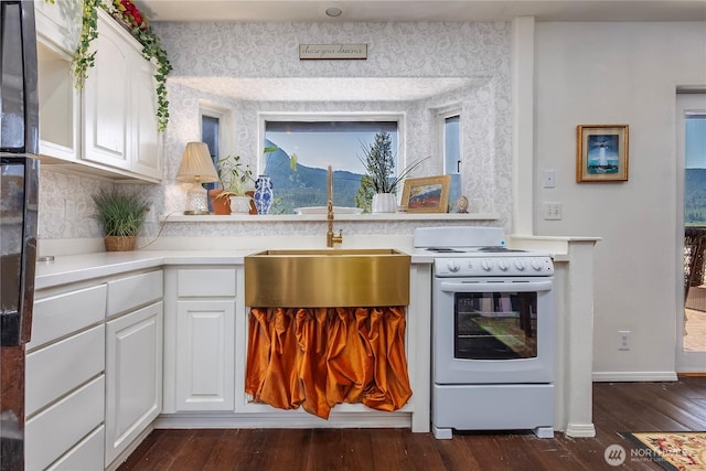 239 Alpine Dr, Packwood, WA 98361 - kitchen featuring electric range, dark wood-type flooring, light countertops, white cabinets, and wallpapered walls