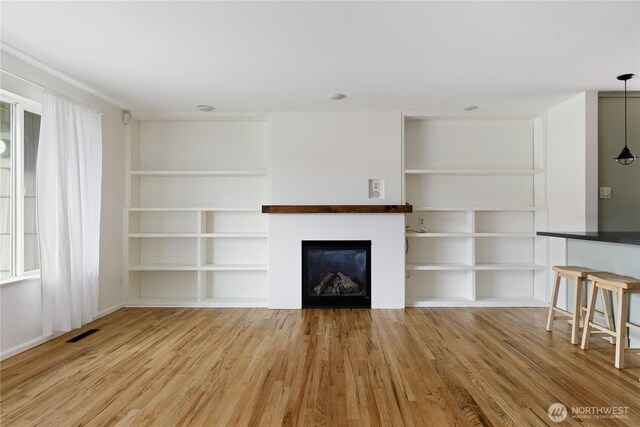 1020 SW Bowmer St, Oak Harbor, WA 98277 - unfurnished living room featuring wood finished floors, built in features, and a fireplace
