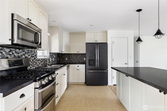 1020 SW Bowmer St, Oak Harbor, WA 98277 - kitchen with stainless steel appliances, dark countertops, a sink, decorative backsplash, and hanging light fixtures