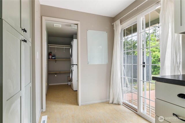 1020 SW Bowmer St, Oak Harbor, WA 98277 - corridor featuring stacked washing machine and dryer, baseboards, and light colored carpet