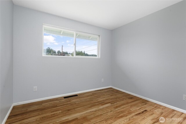 1020 SW Bowmer St, Oak Harbor, WA 98277 - spare room featuring wood finished floors and baseboards