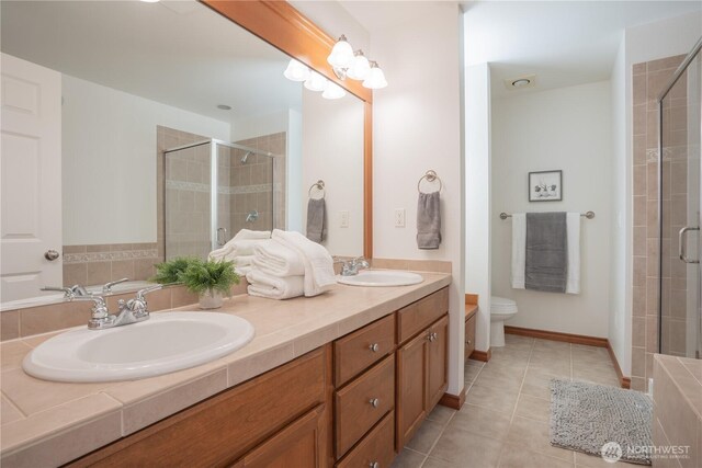 725 N 198th St, Shoreline, WA 98133 - bathroom featuring toilet, a stall shower, double vanity, and tile patterned floors