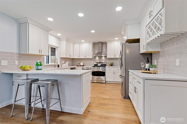 22718 1st Pl W, Bothell, WA 98021 - kitchen featuring stainless steel gas range, wall chimney exhaust hood, a peninsula, decorative backsplash, and recessed lighting
