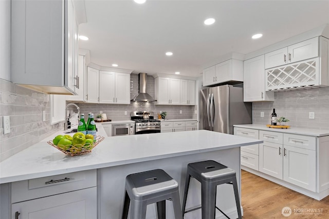 22718 1st Pl W, Bothell, WA 98021 - kitchen with wall chimney exhaust hood, appliances with stainless steel finishes, a sink, a peninsula, and backsplash
