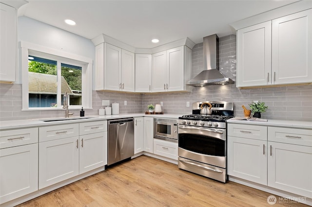 22718 1st Pl W, Bothell, WA 98021 - kitchen featuring wall chimney range hood, appliances with stainless steel finishes, a sink, light countertops, and white cabinetry
