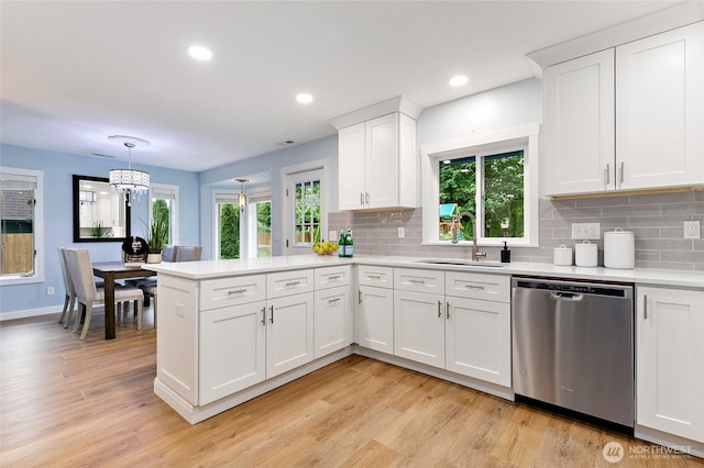 22718 1st Pl W, Bothell, WA 98021 - kitchen with dishwasher, a sink, a peninsula, light countertops, and light wood-style floors