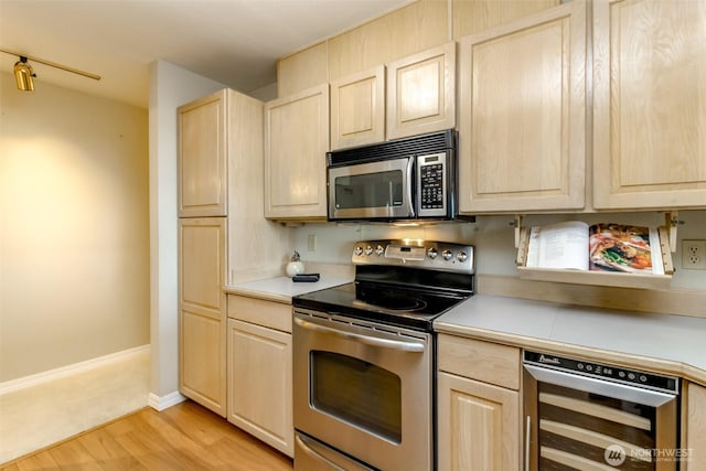 1526 Alki Ave SW Unit 303, Seattle, WA 98116 - kitchen featuring appliances with stainless steel finishes, light brown cabinets, wine cooler, and light countertops