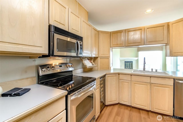 1526 Alki Ave SW Unit 303, Seattle, WA 98116 - kitchen featuring appliances with stainless steel finishes, light brown cabinetry, a sink, and recessed lighting