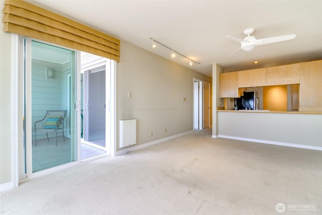 1526 Alki Ave SW Unit 303, Seattle, WA 98116 - unfurnished living room with light carpet, rail lighting, ceiling fan, and baseboards