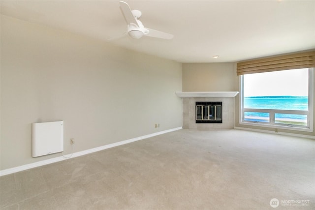 1526 Alki Ave SW Unit 303, Seattle, WA 98116 - unfurnished living room with carpet, a tiled fireplace, baseboards, and ceiling fan
