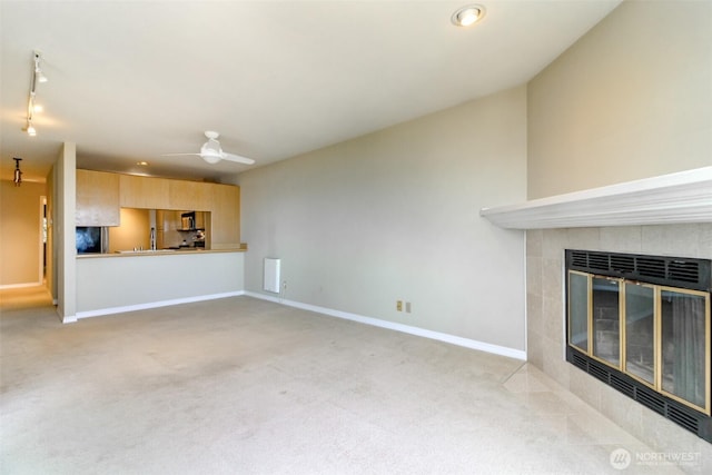 1526 Alki Ave SW Unit 303, Seattle, WA 98116 - unfurnished living room featuring a ceiling fan, carpet, track lighting, a tile fireplace, and recessed lighting