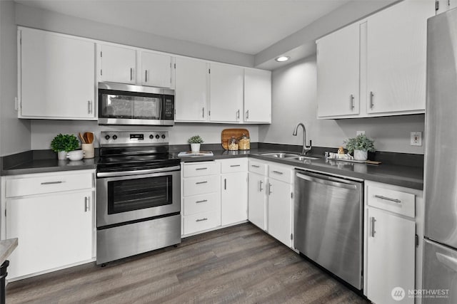 11620 28th St NE, Lake Stevens, WA 98258 - kitchen featuring stainless steel appliances, recessed lighting, dark countertops, dark wood-style floors, and white cabinets