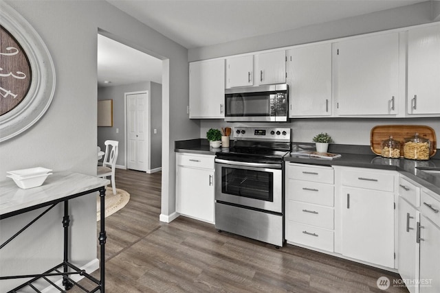 11620 28th St NE, Lake Stevens, WA 98258 - kitchen with stainless steel appliances, dark countertops, dark wood-type flooring, and white cabinetry