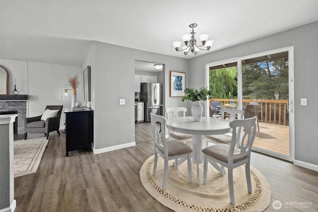 11620 28th St NE, Lake Stevens, WA 98258 - dining area with wood finished floors, a chandelier, and a stone fireplace