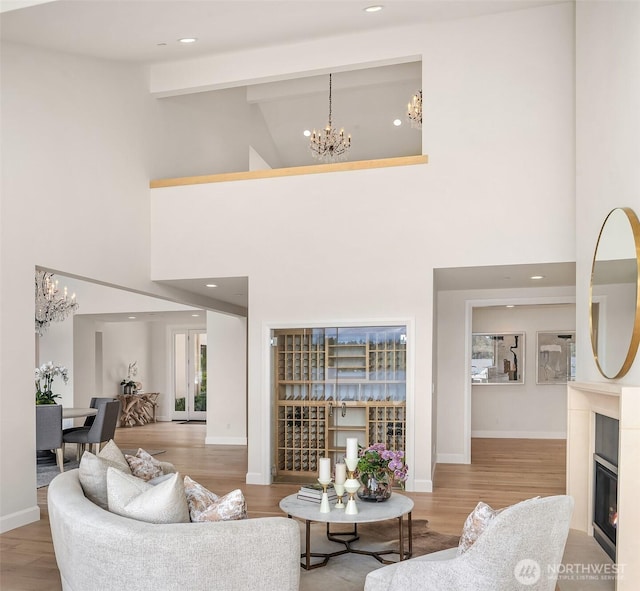 8620 N Mercer Way, Mercer Island, WA 98040 - living area featuring a chandelier, a high ceiling, wood finished floors, a glass covered fireplace, and recessed lighting