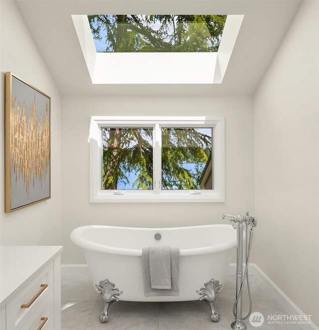 8620 N Mercer Way, Mercer Island, WA 98040 - bathroom featuring a skylight, baseboards, healthy amount of natural light, and a freestanding bath