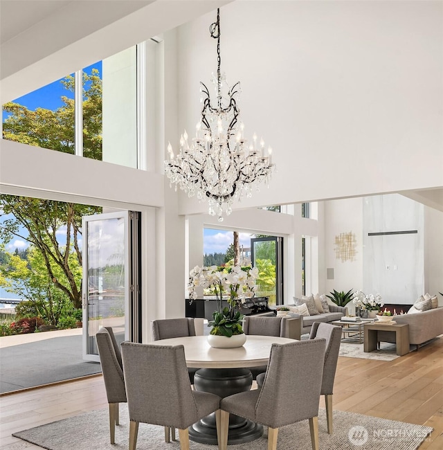 8620 N Mercer Way, Mercer Island, WA 98040 - dining space with a chandelier, light wood finished floors, and a high ceiling