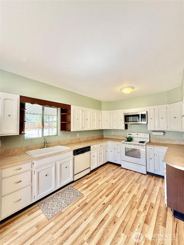926 S 4th Ave, Okanogan, WA 98840 - kitchen with white appliances, a sink, white cabinets, and light countertops
