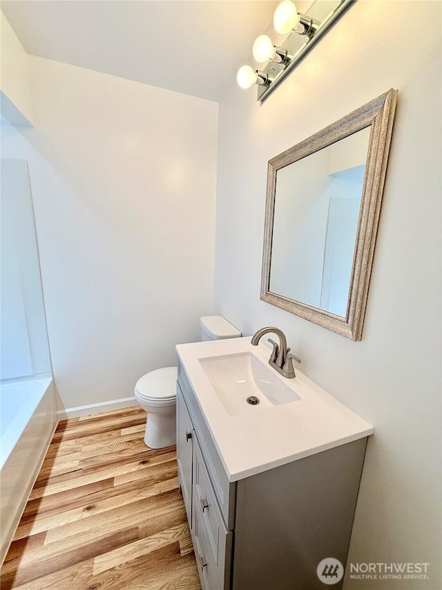 926 S 4th Ave, Okanogan, WA 98840 - bathroom featuring vanity, wood finished floors, toilet, a bath, and baseboards