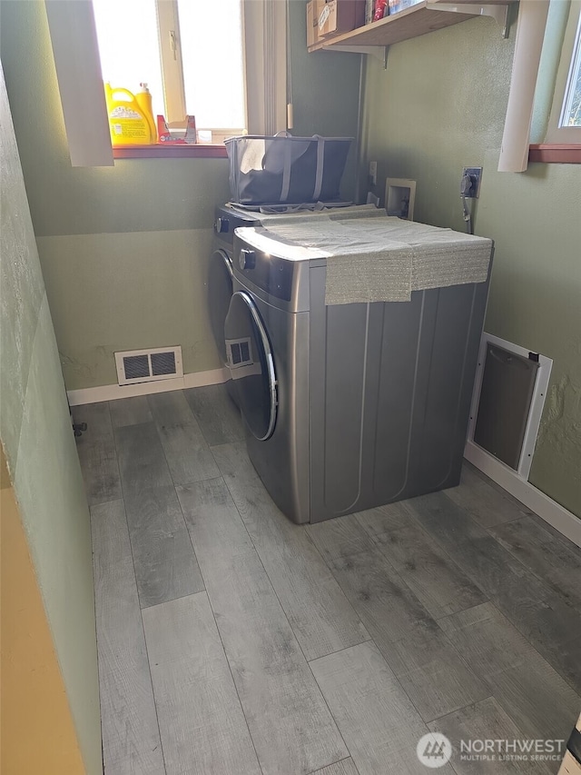 208 N Broadway St, Westport, WA 98595 - laundry room featuring wood finished floors, washer / dryer, and baseboards