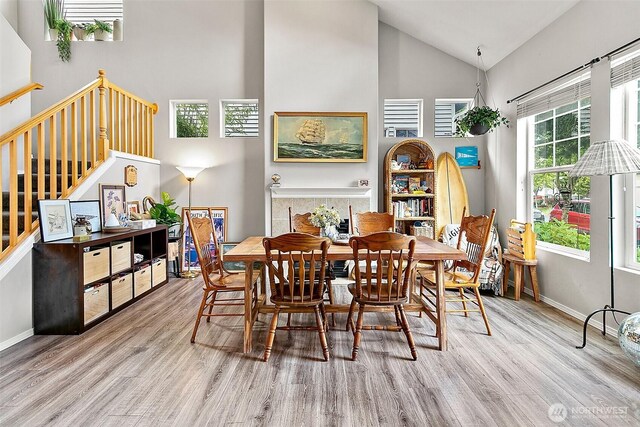 6499 Francis Loop SE, Auburn, WA 98092 - dining space with wood finished floors, high vaulted ceiling, stairs, and baseboards