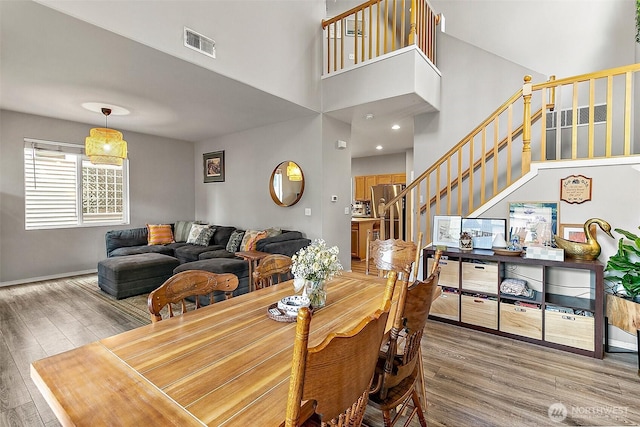 6499 Francis Loop SE, Auburn, WA 98092 - dining space with stairs, wood finished floors, a towering ceiling, and baseboards