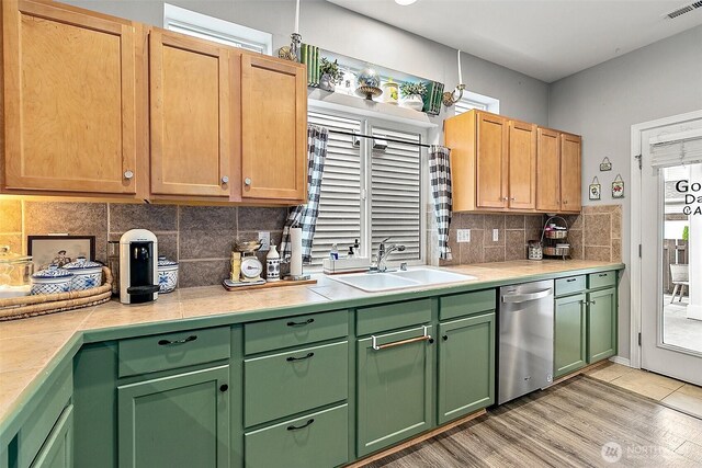 6499 Francis Loop SE, Auburn, WA 98092 - kitchen with dishwasher, a sink, light countertops, tasteful backsplash, and light wood-style floors