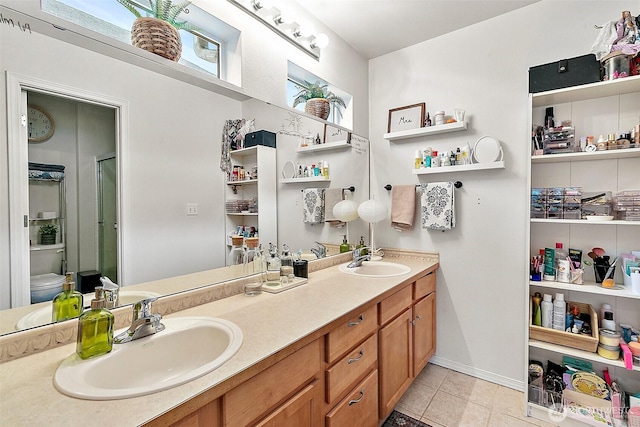 6499 Francis Loop SE, Auburn, WA 98092 - full bathroom featuring double vanity, tile patterned flooring, toilet, and a shower with door
