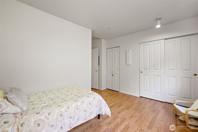 2300 Benson Rd S Unit D3, Renton, WA 98055 - bedroom featuring multiple closets, light wood-type flooring, and baseboards
