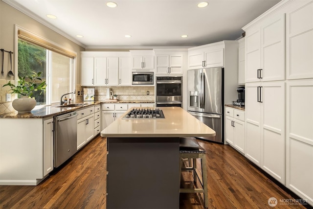 21505 30th Ave SE, Bothell, WA 98021 - kitchen featuring appliances with stainless steel finishes, a kitchen breakfast bar, decorative backsplash, a center island, and white cabinetry