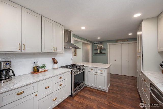 12009 NW Dodson Rd, Ephrata, WA 98823 - kitchen with wall chimney range hood, appliances with stainless steel finishes, a peninsula, dark wood finished floors, and backsplash