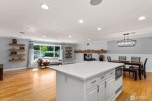 8827 Marlene Ct SW, Olympia, WA 98512 - kitchen featuring stainless steel microwave, white cabinetry, a kitchen island, recessed lighting, and light countertops