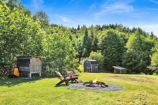 1055 Falls Dr, Bellingham, WA 98229 - view of grassy yard with an outdoor fire pit, exterior structure, and a forest view