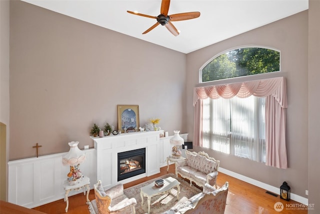 699 Lehman Dr, Camano Island, WA 98282 - living area featuring a glass covered fireplace, a ceiling fan, and wood finished floors