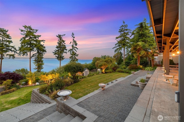 699 Lehman Dr, Camano Island, WA 98282 - patio terrace at dusk with a lawn, a patio, and a water view