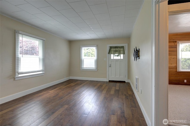 212 Hayes St, Hoquiam, WA 98550 - foyer entrance with plenty of natural light, dark wood-style floors, wooden walls, and baseboards