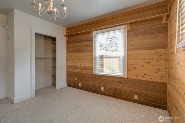 212 Hayes St, Hoquiam, WA 98550 - unfurnished bedroom featuring wood walls, carpet, a chandelier, a closet, and baseboards