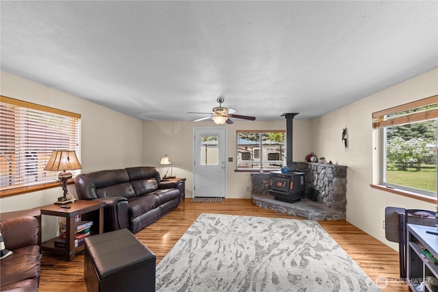 51 Deer Meadow Ln, Naches, WA 98937 - living room with a wood stove, plenty of natural light, wood finished floors, ceiling fan, and a textured ceiling