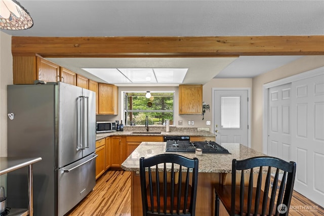51 Deer Meadow Ln, Naches, WA 98937 - kitchen with stainless steel appliances, light wood finished floors, a kitchen island, a sink, and light stone countertops