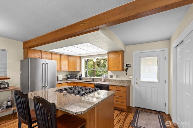 51 Deer Meadow Ln, Naches, WA 98937 - kitchen with stainless steel appliances, a sink, a kitchen bar, light wood-style flooring, and light stone counters