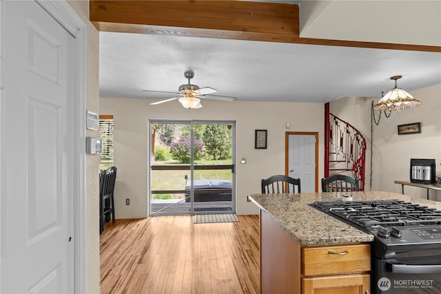 51 Deer Meadow Ln, Naches, WA 98937 - kitchen with gas stove, a ceiling fan, light wood-type flooring, light stone countertops, and a chandelier