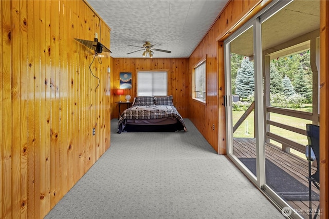 51 Deer Meadow Ln, Naches, WA 98937 - bedroom with light colored carpet, wood walls, access to outside, and ceiling fan