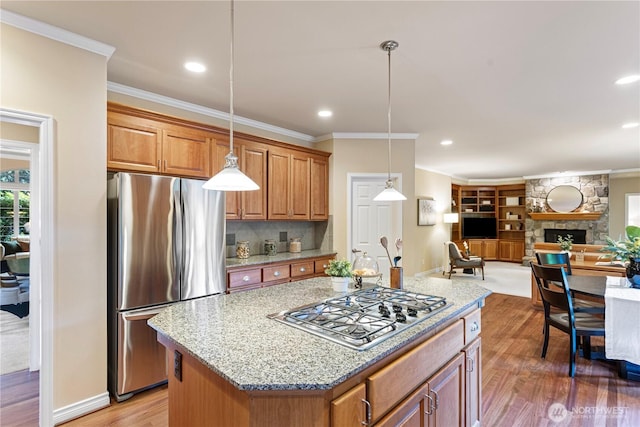 25939 SE 22nd Pl, Sammamish, WA 98075 - kitchen with appliances with stainless steel finishes, open floor plan, crown molding, light stone counters, and light wood finished floors