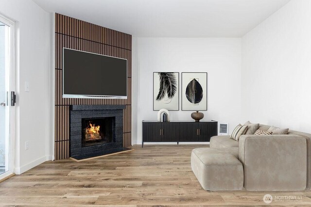 8823 Holly Dr Unit G205, Everett, WA 98208 - sitting room with wood finished floors, a fireplace with flush hearth, and baseboards