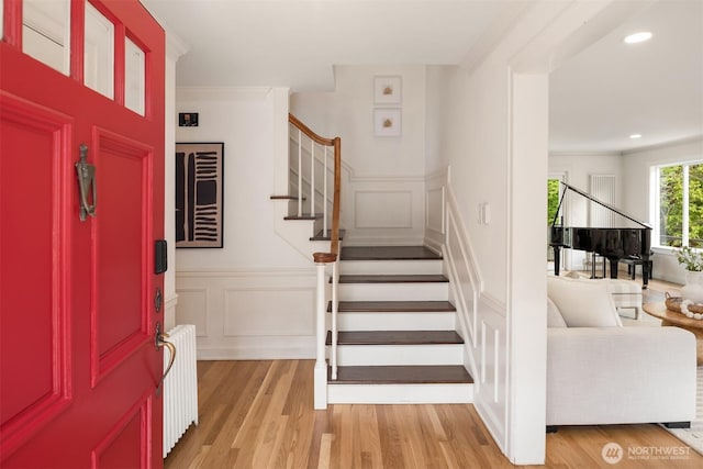 12653 Avondale Rd NE, Redmond, WA 98052 - entryway featuring radiator, a decorative wall, stairs, light wood-style flooring, and wainscoting