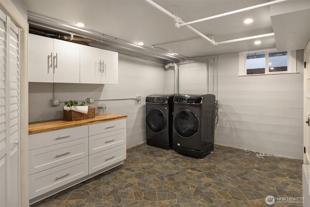 12653 Avondale Rd NE, Redmond, WA 98052 - washroom featuring stone flooring, washer and clothes dryer, recessed lighting, and cabinet space