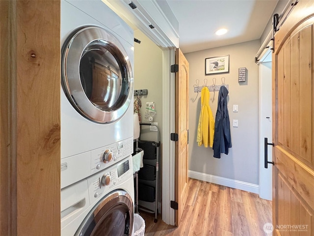 1068 Happy Valley Rd, Sequim, WA 98382 - laundry area featuring stacked washing machine and dryer, a barn door, light wood finished floors, baseboards, and recessed lighting