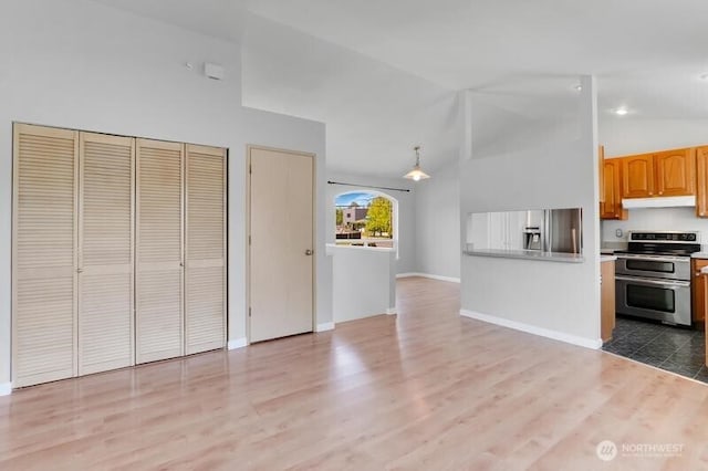 10903 Paine Field Way, Everett, WA 98204 - kitchen with stainless steel appliances, under cabinet range hood, light wood-type flooring, baseboards, and high vaulted ceiling