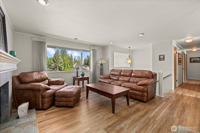 9 199th Pl SE, Bothell, WA 98012 - living room featuring a tiled fireplace, light wood-type flooring, ornamental molding, baseboards, and recessed lighting